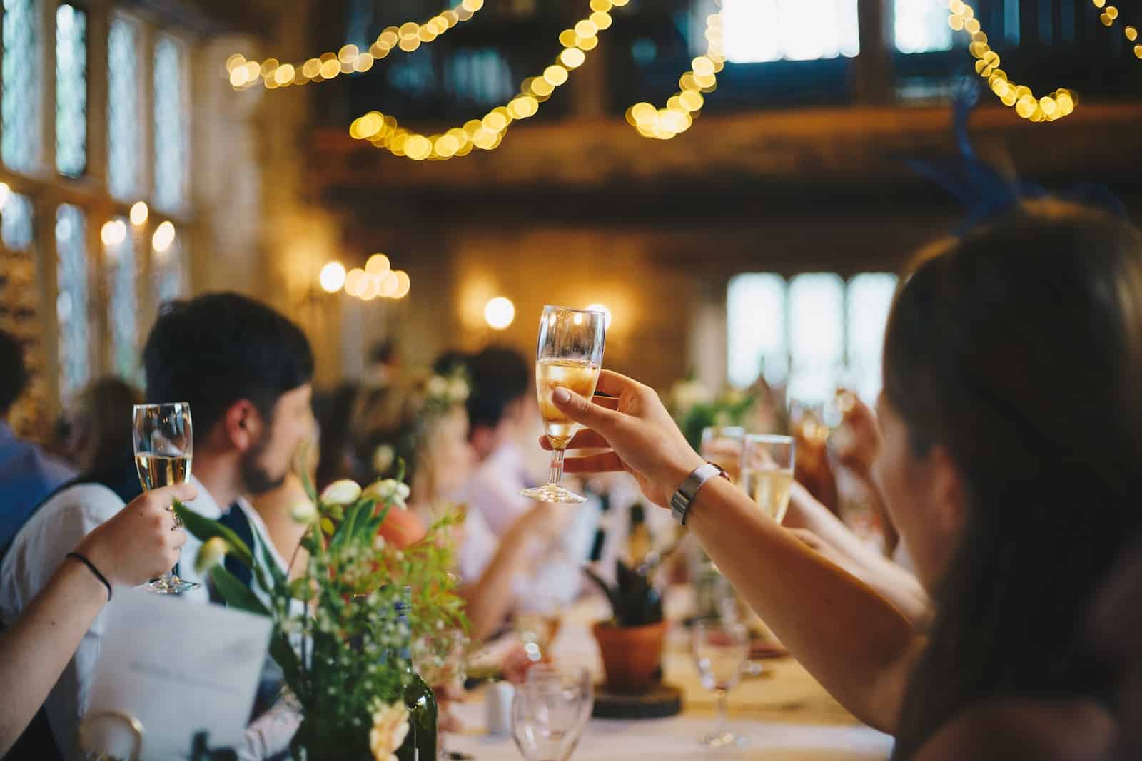Photo By Al Elmes people raising wine glass in selective focus photography